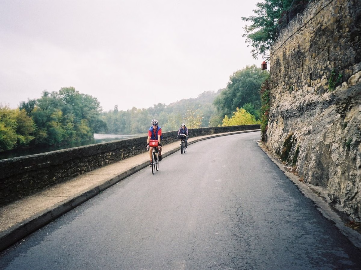 Two cyclists on touring bicycles along the Lot River Route in France