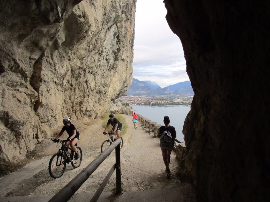 Cyclists and walkers along a section of the Old Ponale Road view view of Riva del Garda